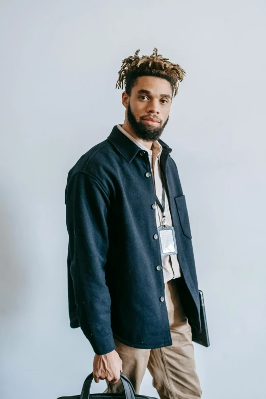 a man with dreadlocks holding a briefcase, trending on pexels, cropped shirt with jacket, structure : kyle lambert, wearing a linen shirt, promotional image