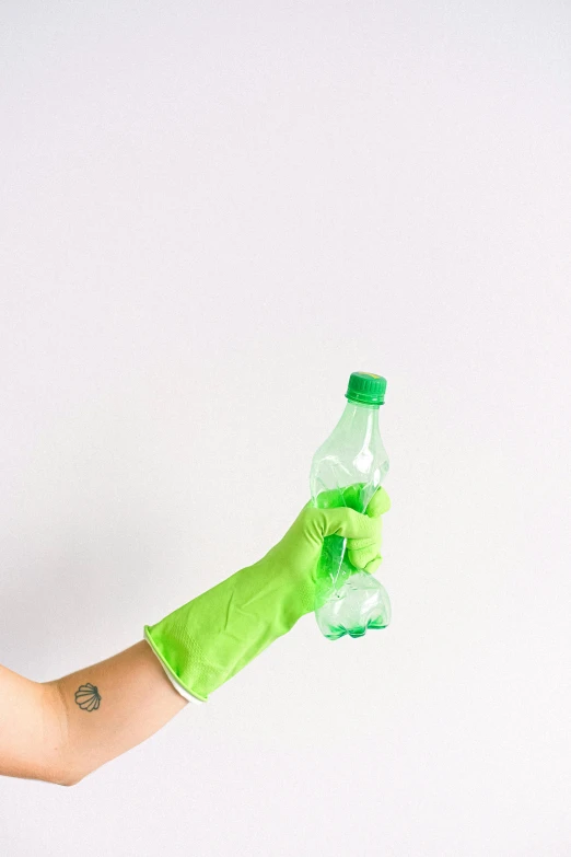 a person in green gloves holding a bottle of water, by Andries Stock, plasticien, empty background, 🍸🍋, cleaning future, made of plastic