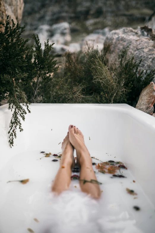 a person laying in a bathtub with their feet in the water, trending on unsplash, lush nature, manuka, made of liquid, tall