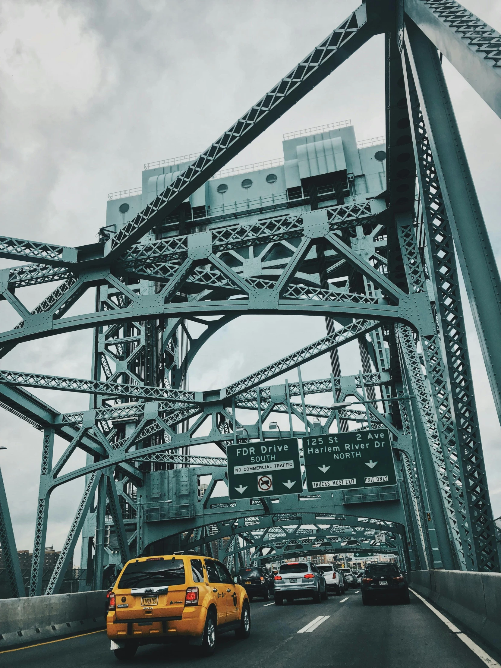 a yellow cab driving across a bridge on a cloudy day, inspired by Elsa Bleda, unsplash contest winner, portland oregon, 😭 🤮 💕 🎀, tall metal towers, teal aesthetic