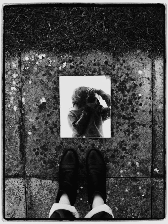 a black and white photo of a person standing in front of a mirror, a black and white photo, by Jan Rustem, street art, feet on the ground, weathered polaroid, the hair reaches the ground, john berry