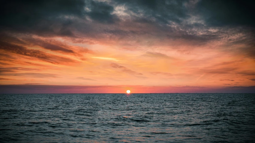 a large body of water under a cloudy sky, pexels contest winner, romanticism, pink sun, middle of the ocean, multicoloured, multiple stories