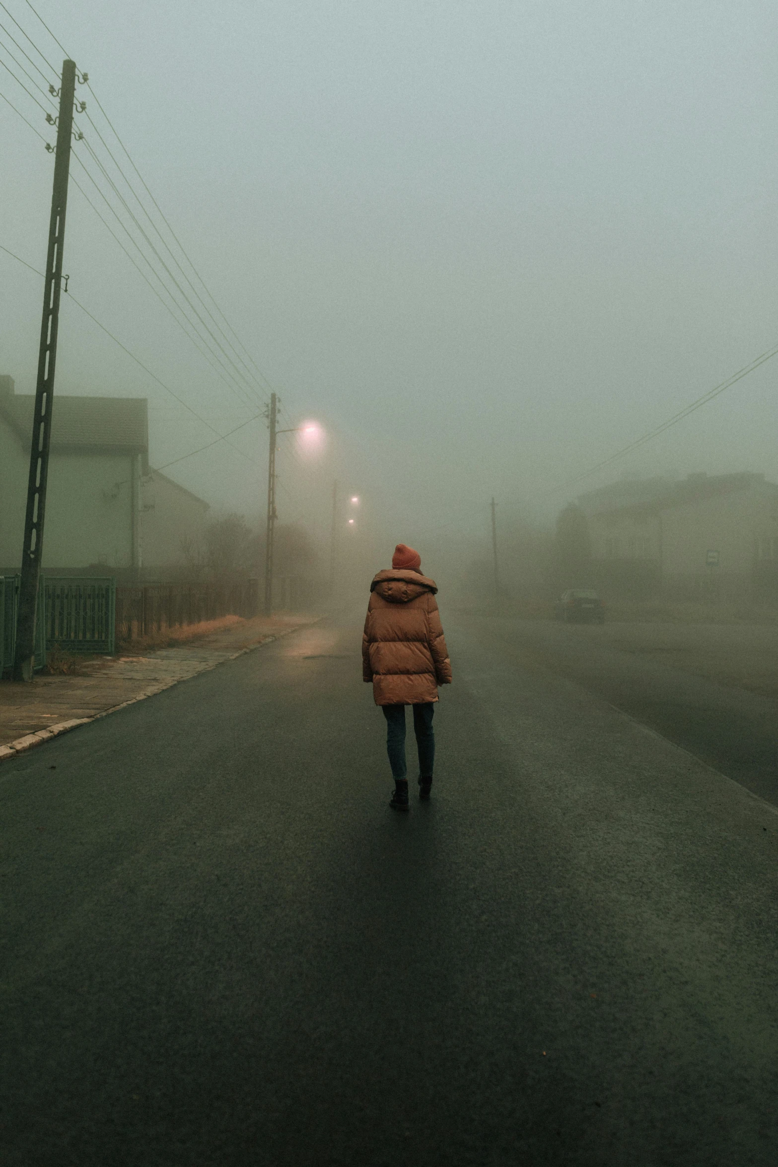 a person walking down a street on a foggy day, an album cover, inspired by Elsa Bleda, pexels contest winner, realism, stålenhag, pollution, 'silent hill ', soviet town