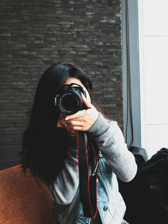 a woman taking a picture of herself with a camera, by Robbie Trevino, black haired girl wearing hoodie, ((sharp focus)), profile image, trending photo