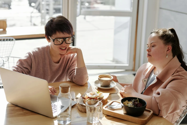 a couple of people sitting at a table with a laptop, by Emma Andijewska, trending on pexels, happening, wearing small round glasses, asian women, avatar image, 9 9 designs