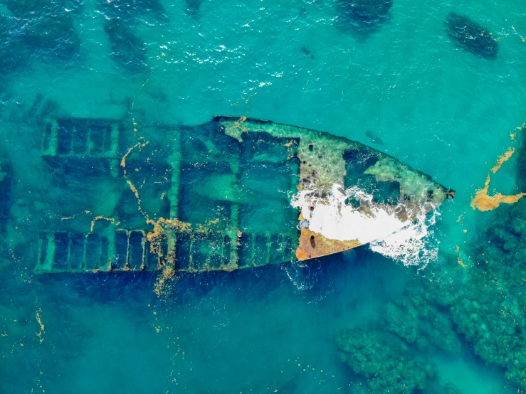 an aerial view of a ship in the ocean, an album cover, pexels contest winner, hurufiyya, shipwrecks, jamaica, thumbnail, damaged