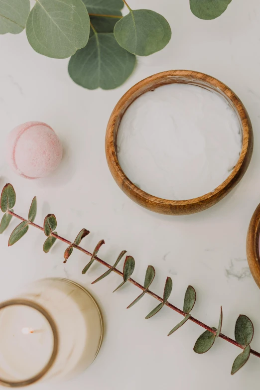 a couple of wooden rings sitting on top of a table, a still life, inspired by Eden Box, trending on unsplash, white marble, soap, powder, with soft bushes