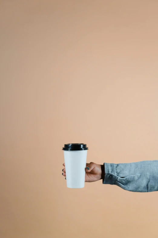 a man holding a cup of coffee in his hand, an album cover, by Andrew Domachowski, trending on unsplash, minimalism, paper cup, 15081959 21121991 01012000 4k, arms out, highly detailed image