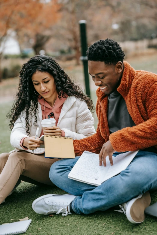 a couple of people that are sitting on the ground, pexels contest winner, academic art, writing on a clipboard, mixed race, promotional image, romantic lead