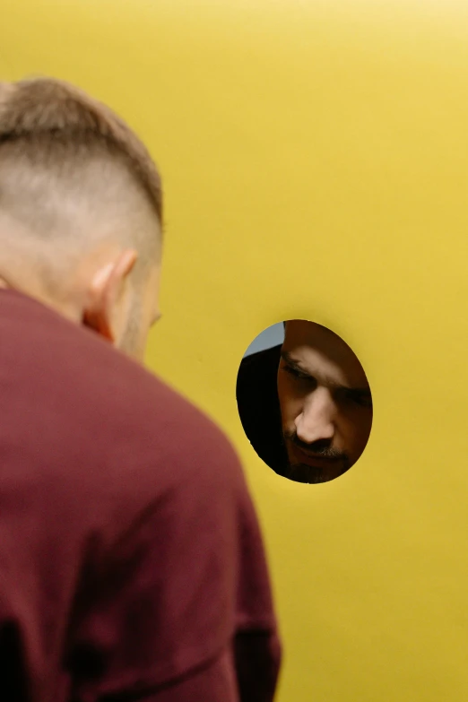 a man looking at his reflection in a mirror, by artist, pexels contest winner, conceptual art, yellow backdrop, black round hole, hide geometry, 15081959 21121991 01012000 4k