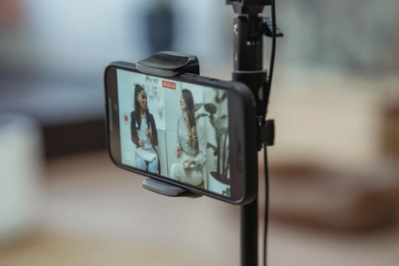 a close up of a cell phone on a tripod, video art, photoshoot for skincare brand, holding a microphone, long shot view, youtube thumbnail