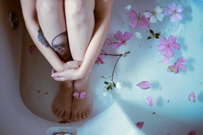 a woman sitting in a bathtub filled with flowers, a photo, inspired by Elsa Bleda, trending on pexels, swollen veins, blue and pink, siting on a toilet, lotus petals