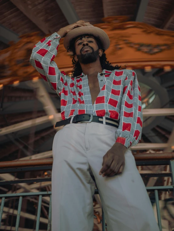 a man in a red and white shirt and white pants, inspired by Theo Constanté, pexels contest winner, afrofuturism, bearded cowboy, 90's photo, button up shirt, ( ( dark skin ) )