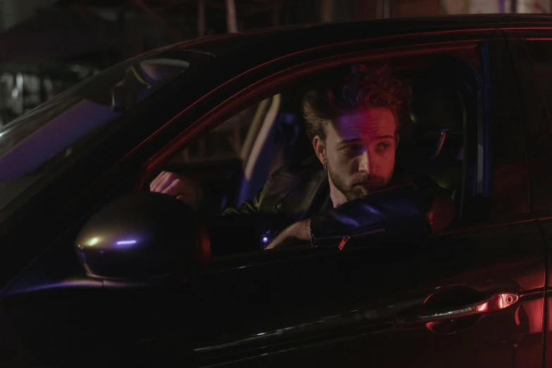 a man sitting in the passenger seat of a car, neon noir, charlie day, press photos, official music video
