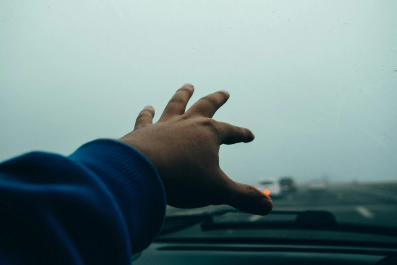 a person's hand on the dashboard of a car, pexels contest winner, foggy sky, looking left, hovering indecision, broken down