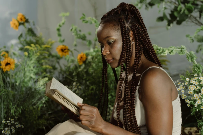 a woman sitting on a bench reading a book, a portrait, by Carey Morris, pexels contest winner, afrofuturism, books and flowers, long braids, avatar image