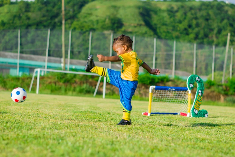 a young boy kicking a soccer ball on a field, pexels contest winner, figuration libre, brazilian flag, 2 years old, square, 15081959 21121991 01012000 4k