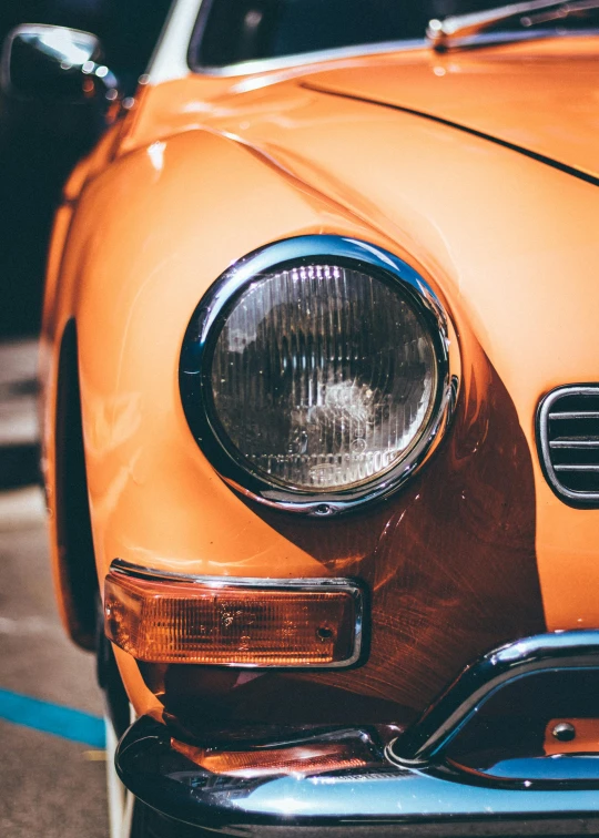 an orange car parked in a parking lot, pexels contest winner, photorealism, round headlights, retro colour, profile image, macro face shot