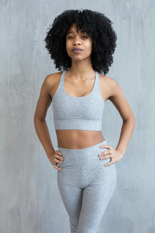 a woman standing with her hands on her hips, trending on pexels, light grey crown, detailed sports bra, designed for cozy aesthetics!, on display