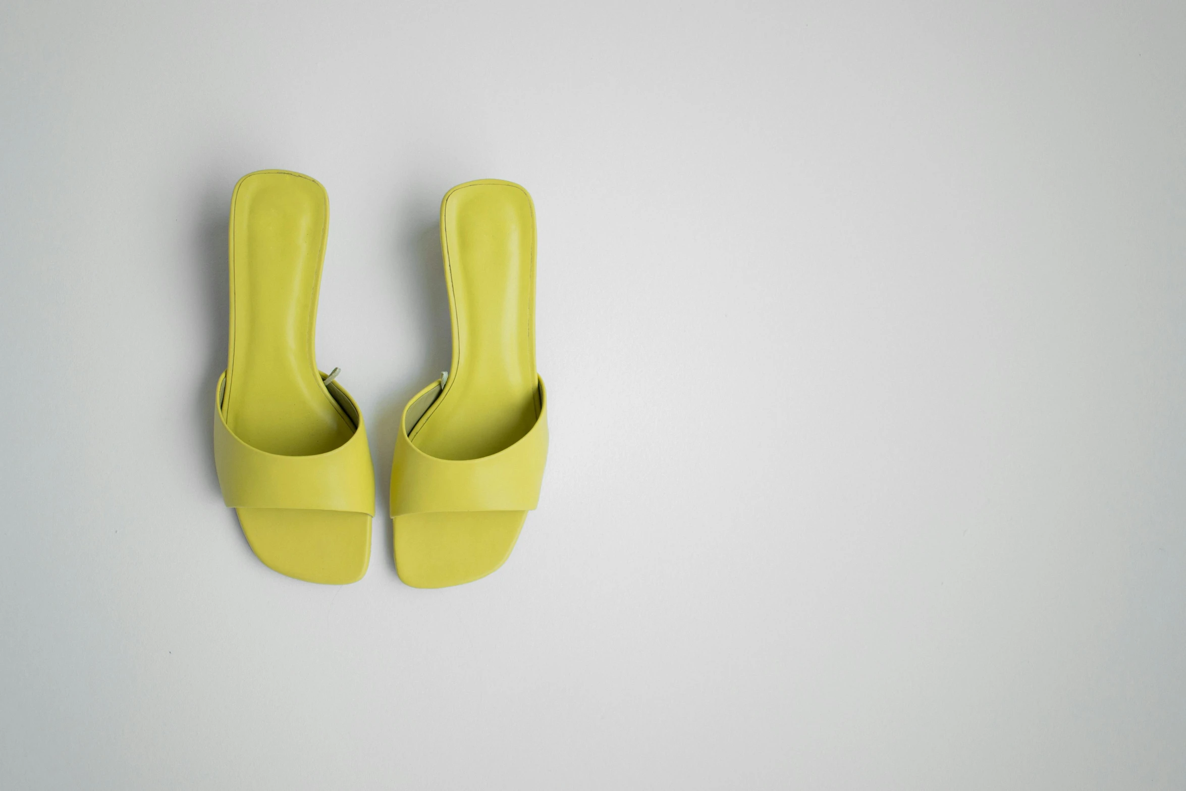 a pair of yellow shoes on a white surface, trending on pexels, 3 d product render, lime green, slides, julia hetta