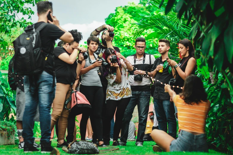 a group of people standing on top of a lush green field, a photo, by Luis Molinari, happening, paparazzi shot, in sao paulo, avatar image, people enjoying the show
