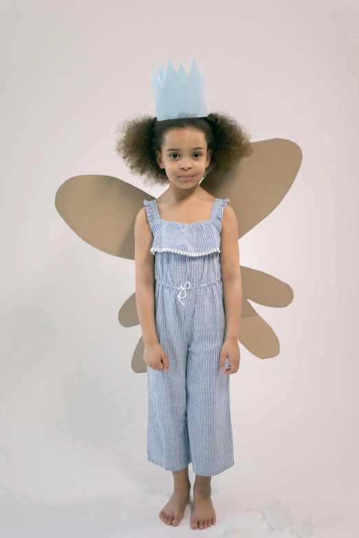 a little girl dressed up in a fairy costume, inspired by Elsa Beskow, featured on reddit, pop art, wearing prison jumpsuit, product introduction photo, tall hat, cardboard cutout