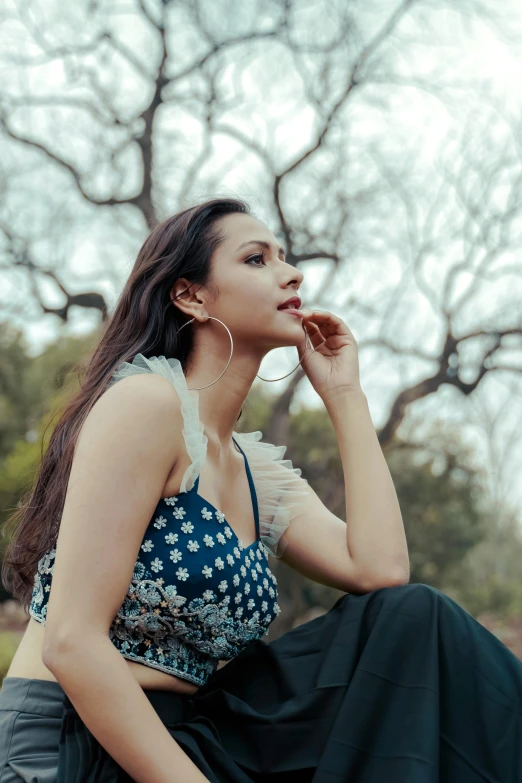 a woman sitting on the ground smoking a cigarette, an album cover, by Natasha Tan, pexels contest winner, romanticism, bollywood, sitting on a tree, candid photo of gal gadot, wearing an elegant tribal outfit