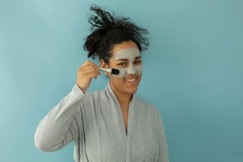 a woman putting a facial mask on her face, by Julia Pishtar, happening, blue gray, spoon placed, full body image, thumbnail