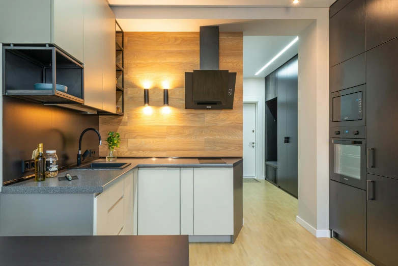 the kitchen is clean and ready for us to use, by Adam Marczyński, pexels contest winner, light and space, inside a modern apartment, top down lighting, wood panel walls, gold and black color scheme