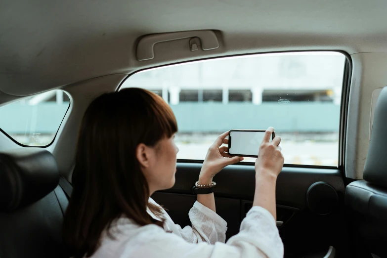 a woman taking a picture of herself in a car, a picture, happening, facing away, avatar image, square, colour photograph