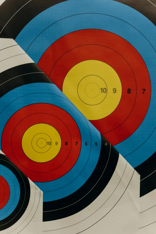 a group of targets sitting on top of a table, trending on pexels, red blue and gold color scheme, longbow, paper, graphic detail