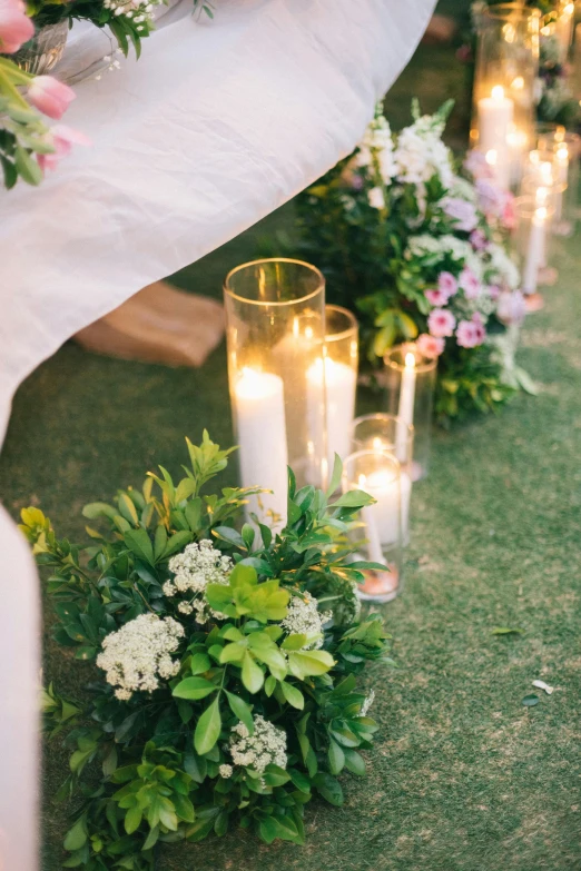 a row of candles sitting on top of a lush green field, bouquet, outside lighting, bed of flowers on floor, upclose