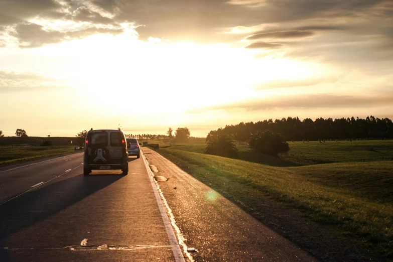 a car that is sitting on the side of the road, by Jesper Knudsen, unsplash, late afternoon sun, cars on the road, trailing off into the horizon, hot summer sun