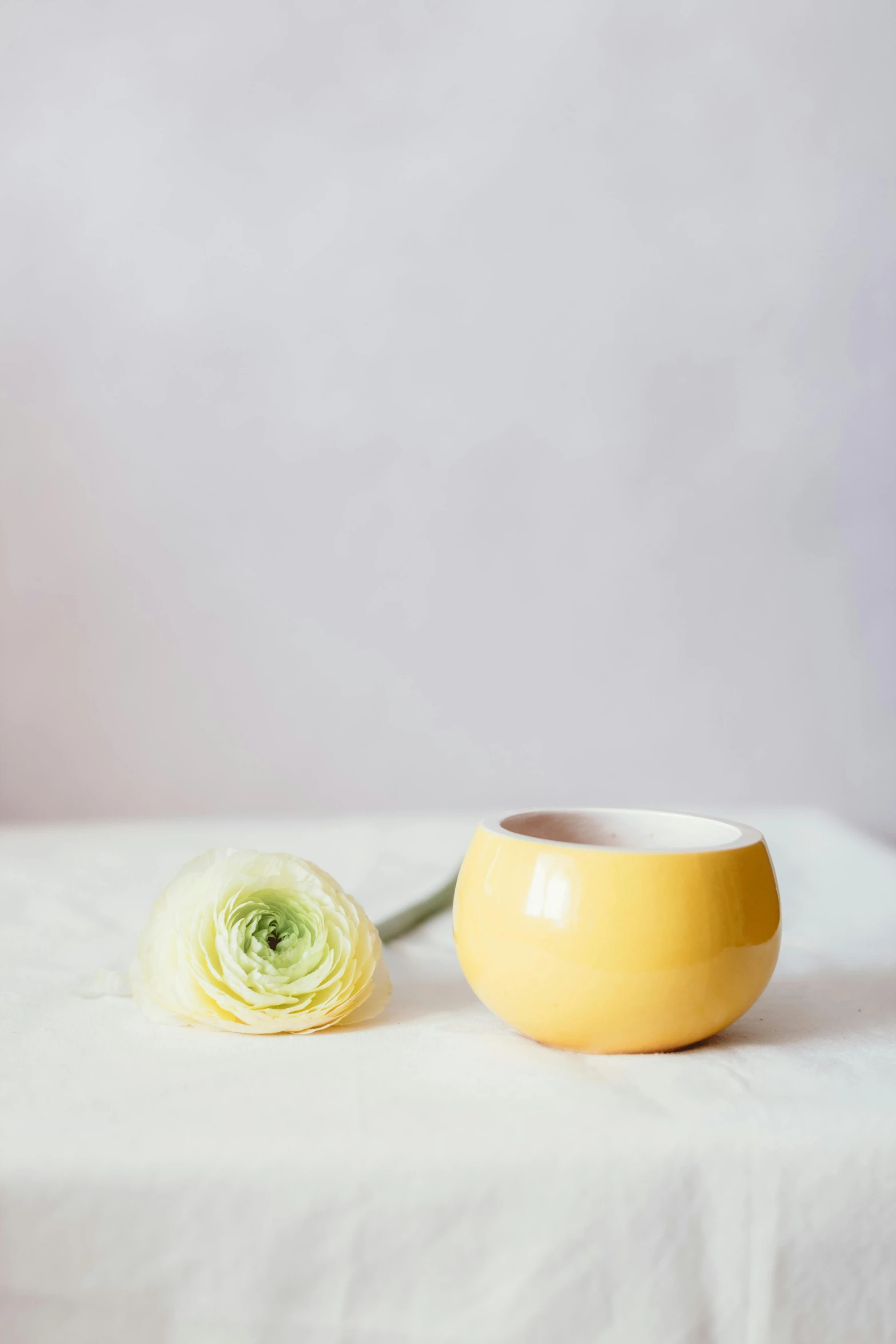 a yellow vase sitting on top of a white table, a still life, unsplash, donut, hero shot, ceramic pot, small