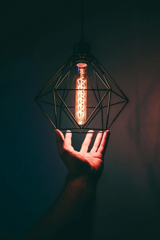 a person holding a light bulb in their hand, pexels contest winner, light and space, geometrical, instagram post, black light, faceted