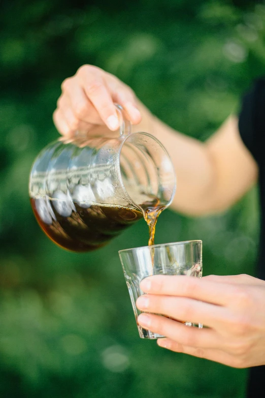 a person pouring a drink into a glass, drink more coffee, al fresco, zoomed in, uncropped