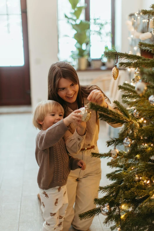 a woman and child decorating a christmas tree, pexels contest winner, square, subtle details, boys, grey