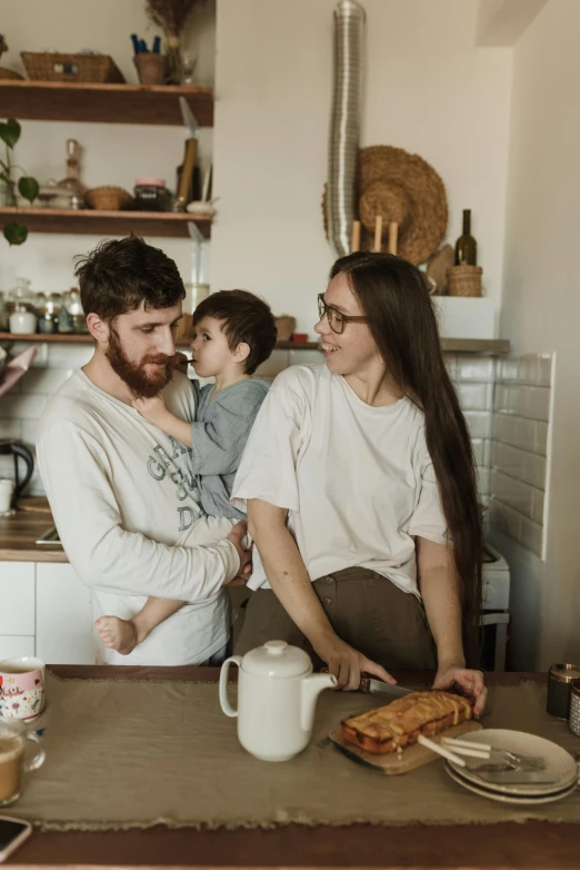 a man and woman holding a child in a kitchen, pexels contest winner, moody neutral hipster tones, on kitchen table, ekaterina, cottagecore hippie