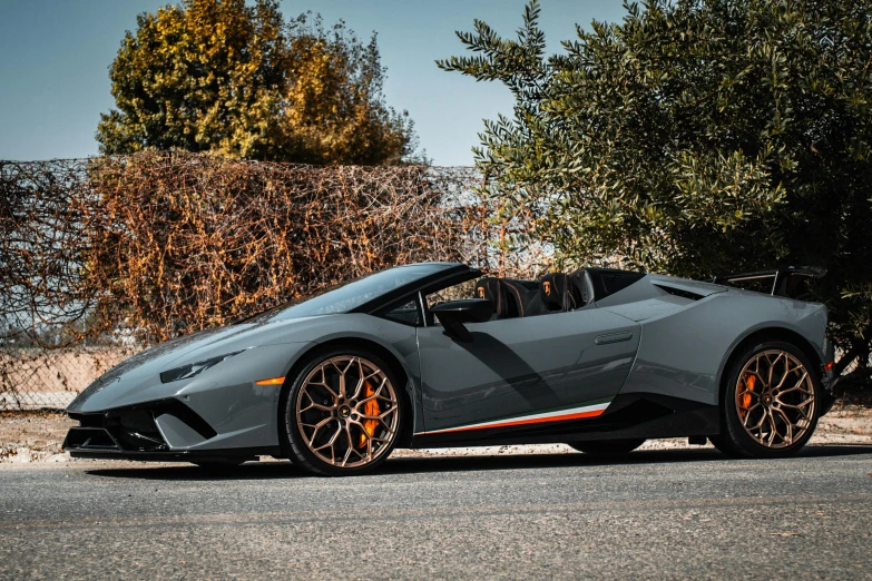 a grey sports car parked on the side of the road, pexels contest winner, renaissance, bold lamborghini style, grey orange, central california, convertible