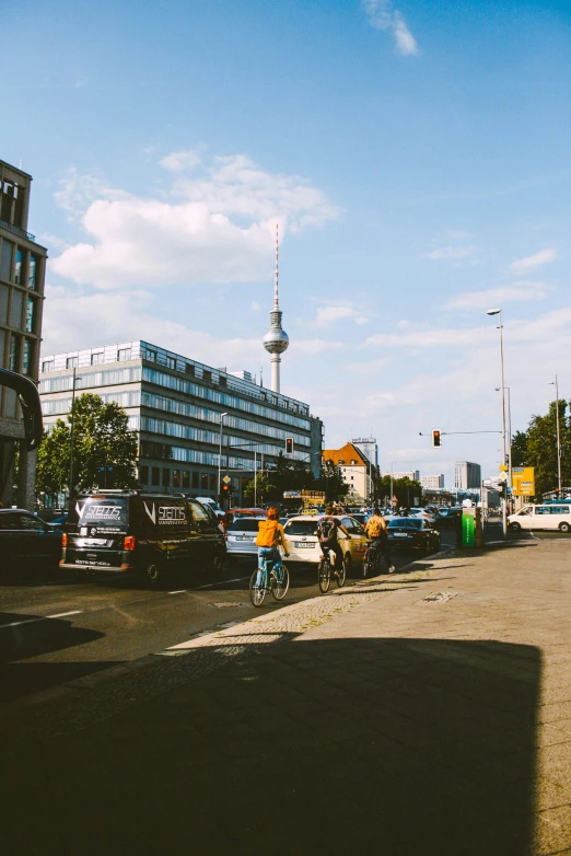 a street filled with lots of traffic next to tall buildings, unsplash, berlin secession, low quality photo, street scene with water tower, 🚿🗝📝, people watching