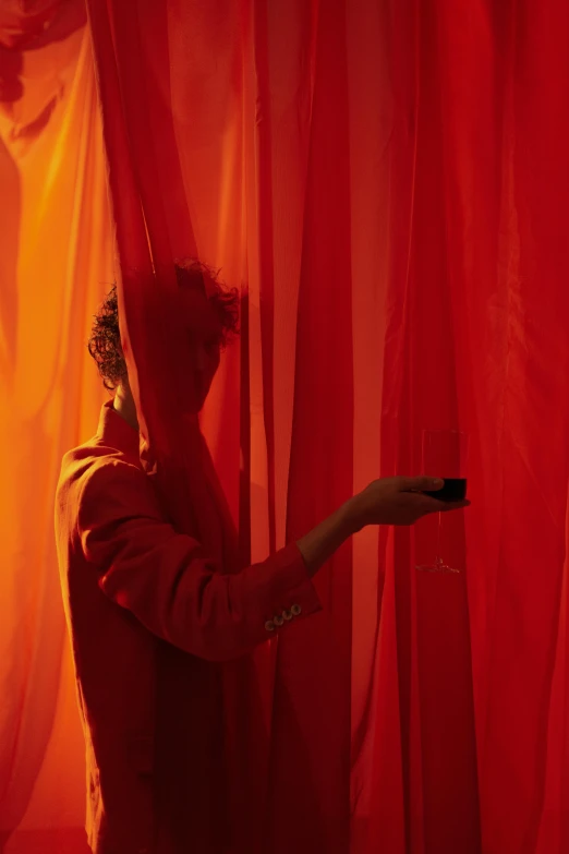 a person standing in front of a red curtain, red and orange colored, fascinated, ignant, production photo