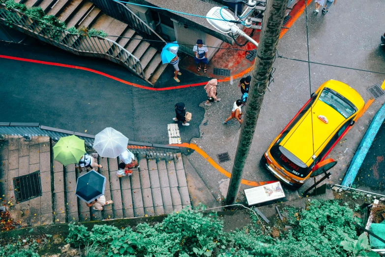 a group of people walking down a street with umbrellas, pexels contest winner, street art, helicopter view, like jiufen, yellow awning, a car