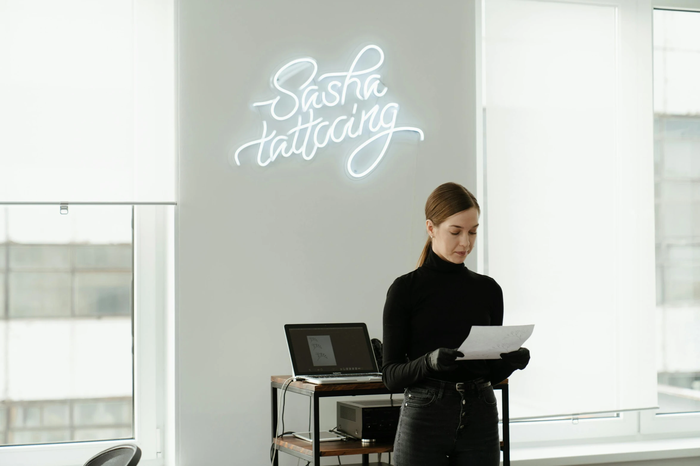 a woman standing in front of a laptop computer, a tattoo, trending on unsplash, bright signage, trending on saatchi art, commercial lighting, drawing on a parchment