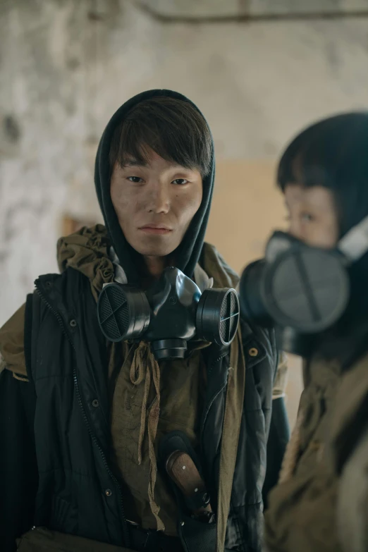 a man in a gas mask standing next to another man, by Jang Seung-eop, trending on pexels, realism, actress, wearing dirty travelling clothes, model is wearing techtical vest, still from anime