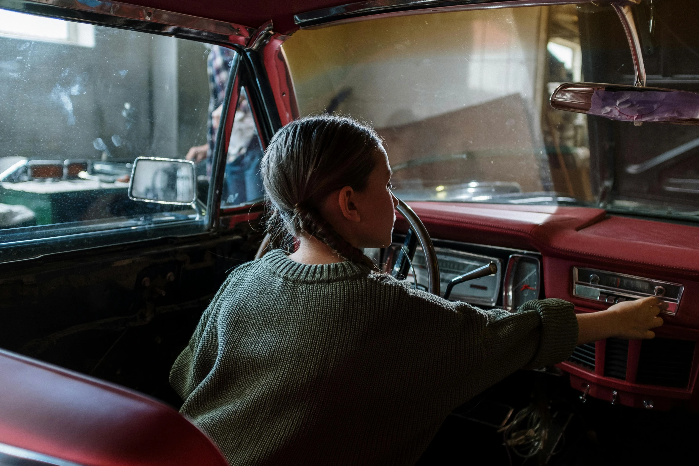 a woman sitting in the driver's seat of a red truck, by Elsa Bleda, pexels contest winner, soviet interior, kid, promotional image, school class