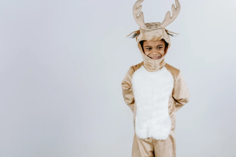 a little boy dressed in a reindeer costume, inspired by Rudolph Belarski, pexels contest winner, minimalism, wearing animal skin clothing, creamy, tan, animation