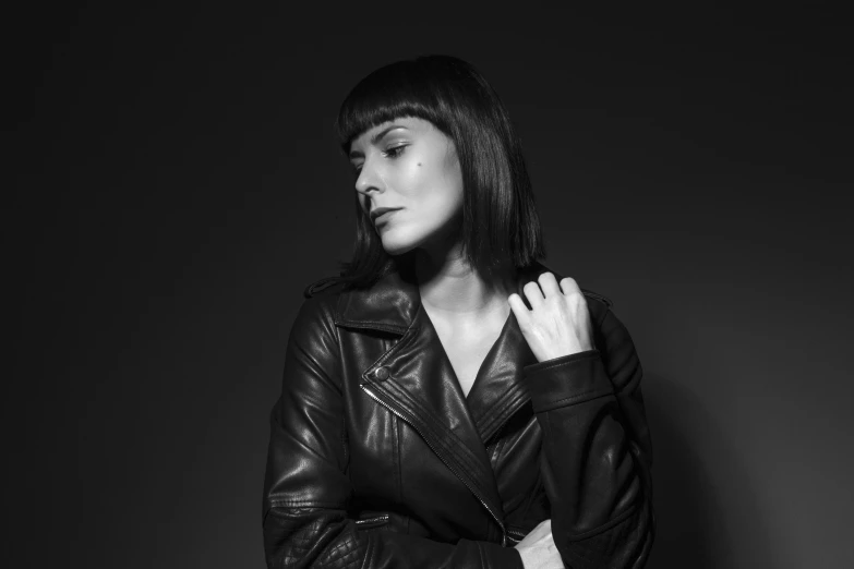 a black and white photo of a woman in a leather jacket, by Kristian Zahrtmann, dark. studio lighting, she has black hair with bangs, 15081959 21121991 01012000 4k, promotional image
