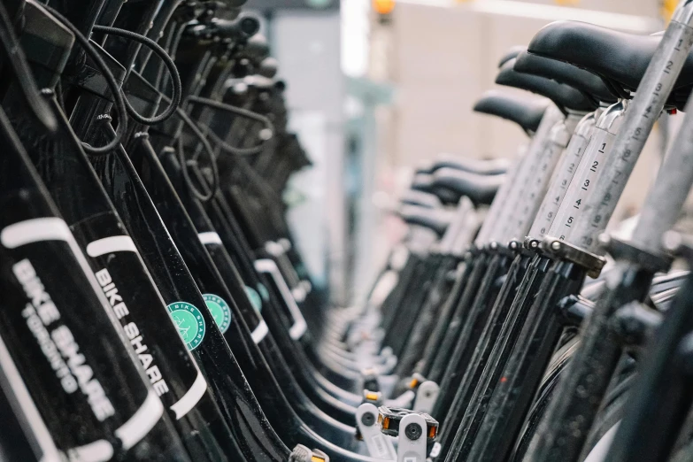 a row of bicycles parked next to each other, unsplash, private press, black and green, the store, closeup of arms, facing away