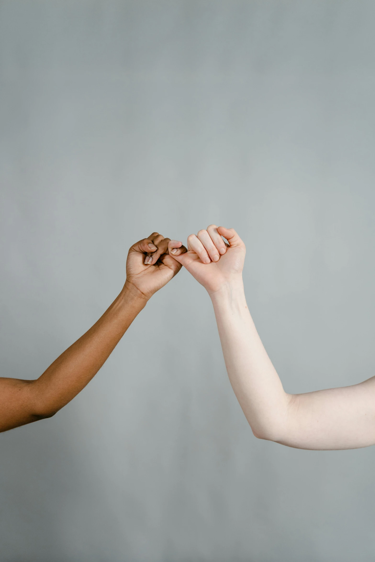 a couple of women standing next to each other, by Arabella Rankin, trending on pexels, renaissance, white bandage tape on fists, mix of ethnicities and genders, gradient brown to silver, laying down with wrists together