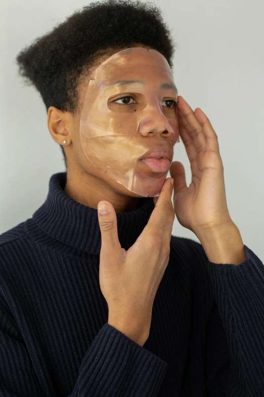 a man putting a facial mask on his face, an album cover, trending on pexels, renaissance, on clear background, light brown skin, non binary model, high angle shot